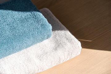 Folded textile towels on the beige wooden table