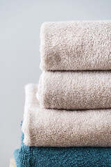 Folded white and blue towels on the grey background