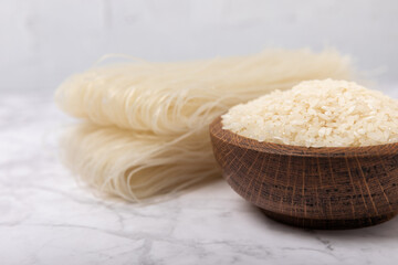 rice noodles. Noodles with rice flour on a white marble background. Funchoza. Dry rice noodles.Close-up.Copy space. Place for text.