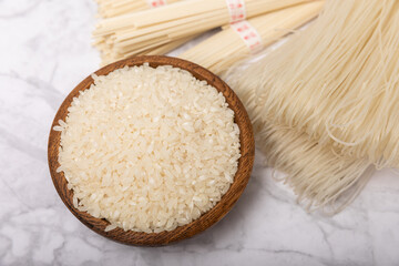 rice noodles. Noodles with rice flour on a white marble background. Funchoza. Dry rice noodles.Close-up.Copy space. Place for text.