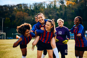 Multiracial women's soccer team has fun and celebrates after victory.