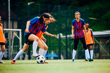 Women's soccer team exercising on playing field.