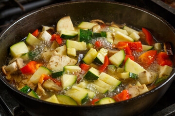 Frying pan with chopped stewed vegetables in sauce and spices .