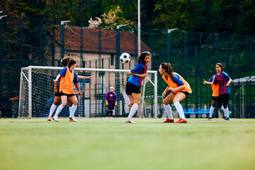 Young female players during soccer training at stadium.