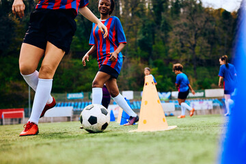 Unrecognizable soccer player practicing with ball during sports training.