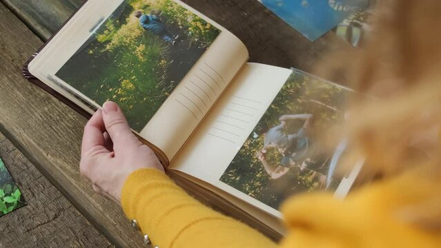 Person flipping through photo album filled with printed images of cherished memories. Photo printing concept.