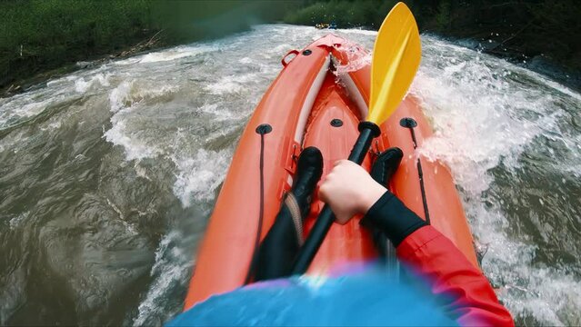 A man on rafting floats on a mountain river through the rapids in spring.