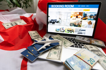 laptop with travel, money and canada flag