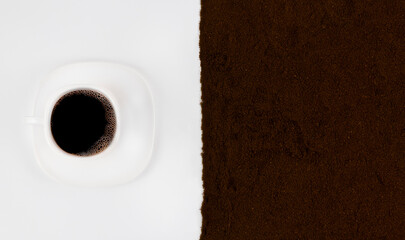 Cup of coffee with ground coffee on a white background.