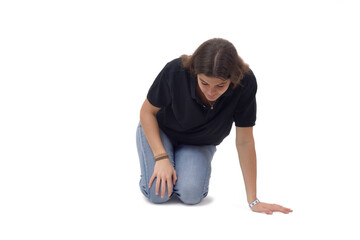front view a young girl who is on her knees on the floor looking for something on a white background