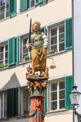 Fototapeta na wymiar Justice Fountain in Solothurn down town center. Built in 1561, Justice is symbolised by Madame Justitia. She is blindfolded and carries a sword in her right hand and a pair of scales in her left.