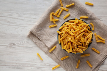 Homemade Raw Organic Caserecce Pasta in a Bowl on a white wooden background, top view. Flat lay, overhead, from above. Space for text.