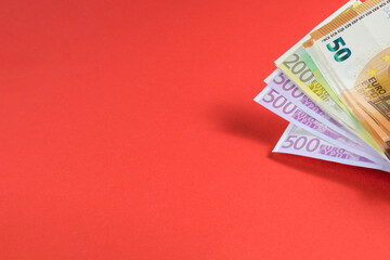 Euro banknotes on a red background. different denomination. Located in the top right corner. copy space