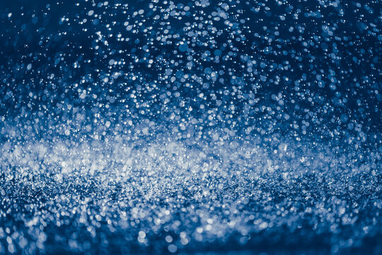 rain water drops on the ground, blue bokeh background, close-up view