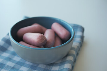 Mini Sausage in a red color bowl on white
