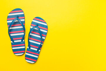 Bright flip flops on color background, top view