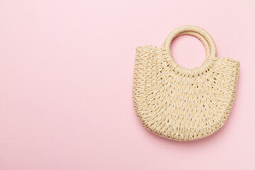 Straw bag on color background, top view