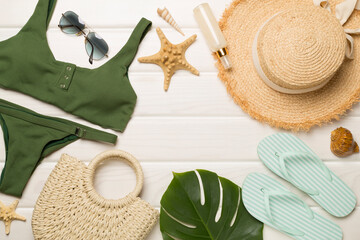 Beach accessories on wooden background, flat lay