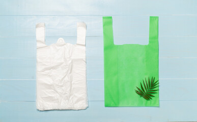 Plastic and biodegradable bag on wooden background, top view