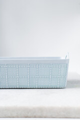 pastel blue organisation basket with a white background, Plastic blue basket for home organisation, pastel blue basket with a woven pattern