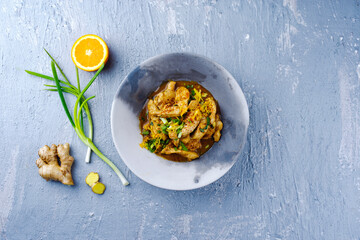 Traditionelle Hähnchen Filet mit Orange und Frühlingszwiebel in aromatischer Gemüse Brühe...