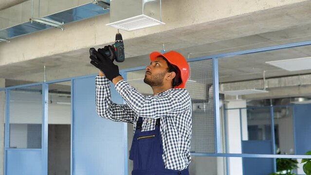 Ventilation system installation and repair service. Indian hvac technician at work