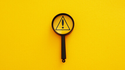 Magnifier glass with triangle caution warning sign for notification error and maintenance concept