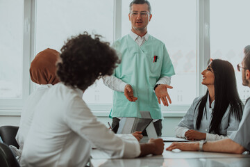 Fototapeta premium A group of multiethnic medical professionals including doctors, surgeons, and nurses are gathered in a hospital setting discussing patient care and using modern technology to address challenges in