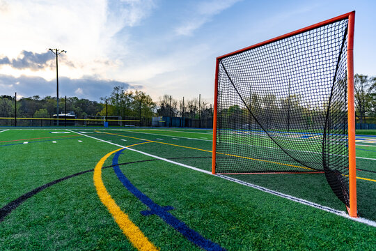 Late afternoon photo of a lacrosse goal on a synthetic turf field before a night game.
