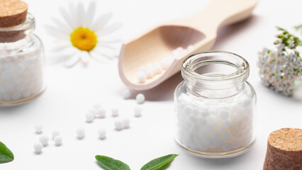 Composition of homeopathic medicines and medicinal plants on a white table