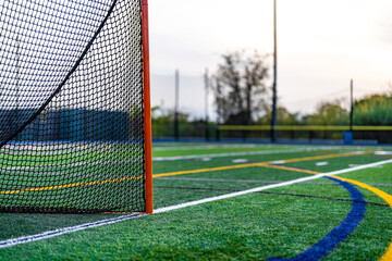 Fototapeta premium Late afternoon photo of a lacrosse goal on a synthetic turf field before a night game. 