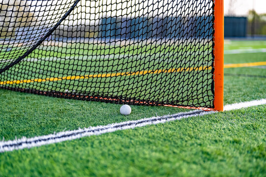 Late afternoon photo of a lacrosse goal on a synthetic turf field before a night game.
