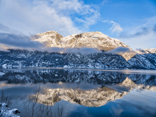Fototapeta na wymiar Snow capped mountains on Hardangerfjord in Eidfjord village, Norway