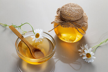 Chamomile syrup in a small bowl and jar on the kitchen table