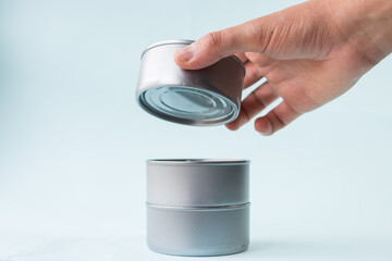 Hand taking food cans on blue background