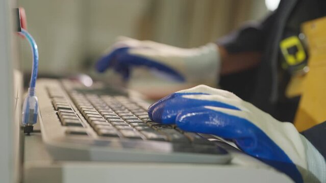 Closeup engineer hand typing information at modern factory.