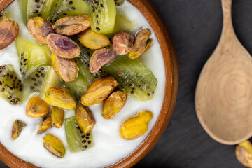fresh green yogurt with pieces of kiwi and pistachios