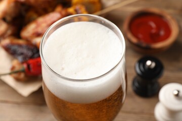 Glass of tasty beer on table, closeup view