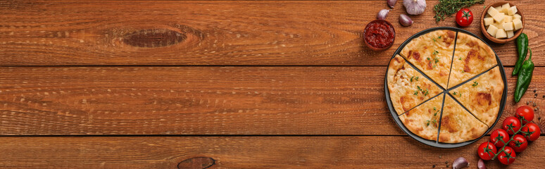 Delicious Megrelian khachapuri served on wooden table, flat lay. Banner design with space for text