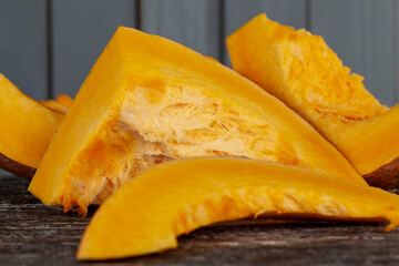 Sweet ripe orange pumpkin is sliced on the table