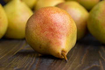 A yellow ripe pear with a red side on the table