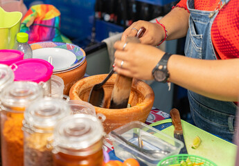 Woman making papaya salad in a mortar.