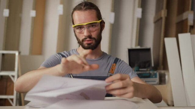 Male craftsman working in workshop. He checking desing in computer.