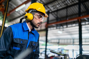Business of factory production and construction work technology, Professional engineer person wearing safety helmet hard hat to using machinery equipment of industry facility in manufacturing plant