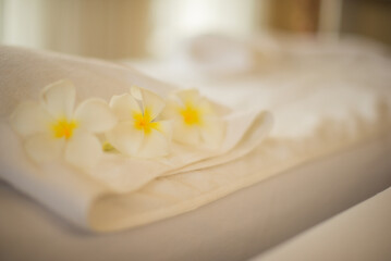 Obraz na płótnie Canvas Frangipani flowers and towels placed on the bed represent relaxation in the spa.