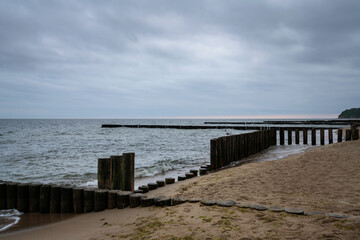Fototapeta na wymiar View of the Baltic Sea and wooden breakwaters of the city beach on a cloudy summer day, Svetlogorsk, Kaliningrad region, Russia