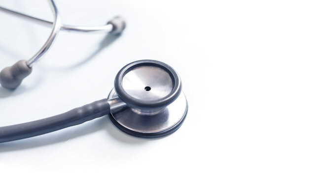 Panorama of medical stethoscope on white blur background with copy space inside hospital.Close up photo of tool for doctor or veterinary use.Beautiful clipboard for text.Clean ear piece and tube.