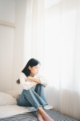 Young attractive asian woman lying at home living room couch feeling sad tired and worried suffering depression in mental health, problems and broken heart concept.