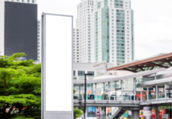 Mock up white LED display vertical billboard on tower pole with cityscape view. clipping path for mockup