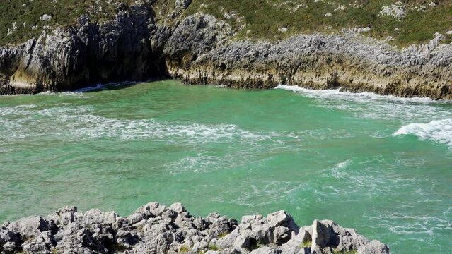Sea waves that are introduced inland from the coast by a channel between cliffs, Asturias, Spain.